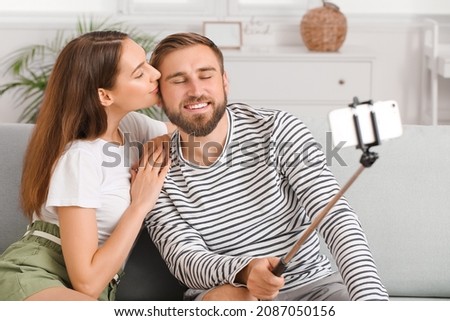 Young couple taking selfie at home