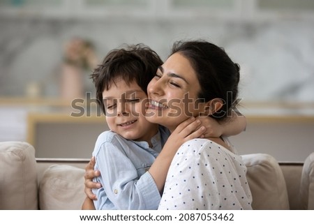 Sincere loving young Indian woman cuddling cute little kid son, showing tender feelings. Happy two generations family enjoying sweet weekend moment together, relaxing at home. Royalty-Free Stock Photo #2087053462