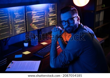 Photo of serious professional programmer look camera improving debugging service experience dark loft space