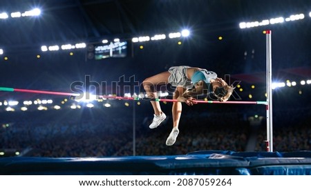 High Jump Championship: Professional Female Athlete on World Championship Successfully Jumping over Bar. Shot of Competition on Stadium with Sports Achievement Experience. Determination of Champion. Royalty-Free Stock Photo #2087059264