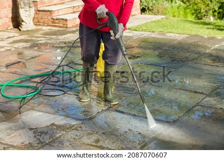 Jet washing, pressure washing or cleaning a garden patio with a jet wash, UK 