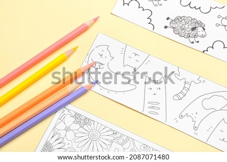Cute bookmarks with pencils on color background