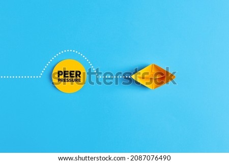 Paper boat overcomes the obstacle of peer pressure. To avoid or to deal with peer pressure concept. Royalty-Free Stock Photo #2087076490