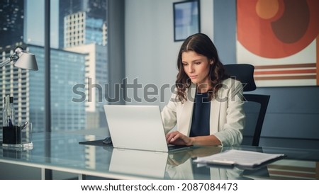 Portrait of Young Successful Caucasian Businesswoman Sitting at Desk Working on Laptop Computer in City Office. Ambitious Corporate Manager Plan Investment Strategy for e-Commerce Project. Royalty-Free Stock Photo #2087084473