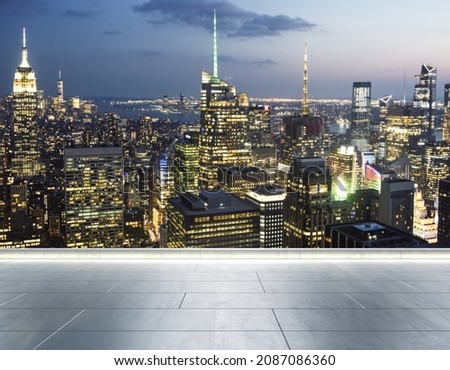 Empty concrete rooftop on the background of a beautiful blurry New York city skyline at evening, mockup