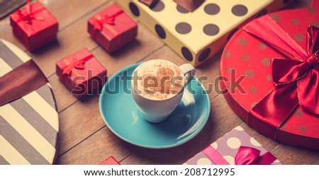 Cup of coffee and christmas gifts.