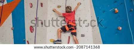 Boy at the climbing wall without a helmet, danger at the climbing wall BANNER, LONG FORMAT