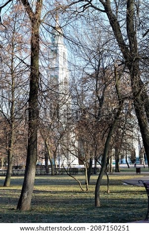 The picture shows the park in late autumn, where a church is visible through the branches of trees without leaves.