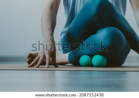 Person doing yin yoga and myofascial release on shin muscle. Concept: self-care practices at home, SMFR, myoyin Royalty-Free Stock Photo #2087152438