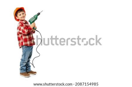 Flyer with funny little boy, kid in image of builder, architect in orange protective helmet using drill isolated on white background. Concept of childhood, study, jobs, games, career, imitation, ad Royalty-Free Stock Photo #2087154985
