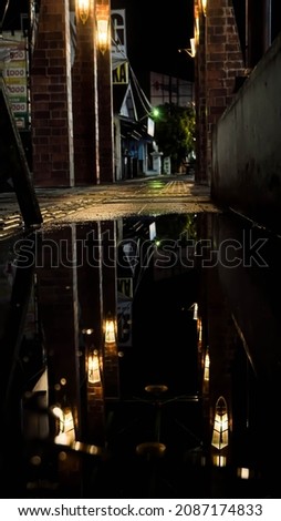 Ambarawa, Central Java, Indonesia - December 04 2021 : reflection of city lights on the sidewalk of the city of Ambarawa, Indonesia

