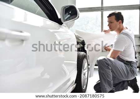 car mechanic repairs car bodywork of a vehicle after a traffic accident  Royalty-Free Stock Photo #2087180575