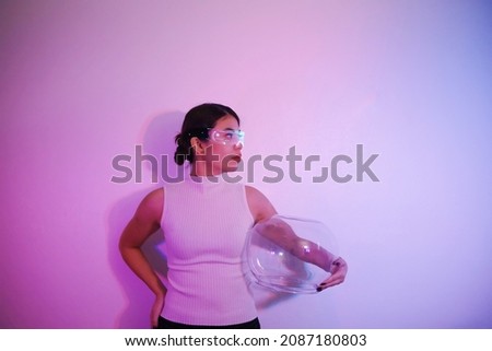 Beautiful Asian woman  with VR glasses, playing with blue and pink light. The concept of cyber game and the future