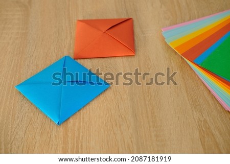 closeup colored paper, material for scrapbooking, origami, figures from paper, envelope in Japanese origami technique, concept of making and creating by hand for children's game