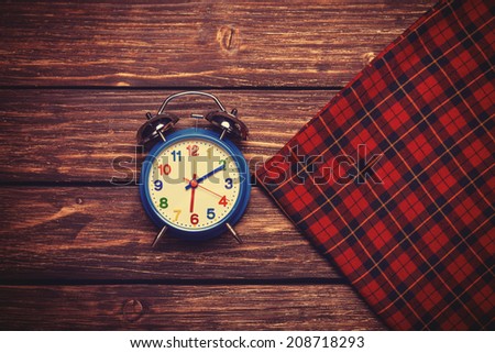 Alarm clock and scarf. Photo in retro color style.