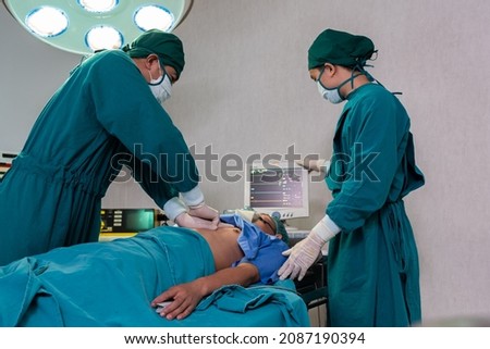 Selective focus at defibrillator while doctor use it to pump at chest of unconscious with low heart rate patient to save life while doing medical surgery inside of operating room. Emergency aid, CPR.
