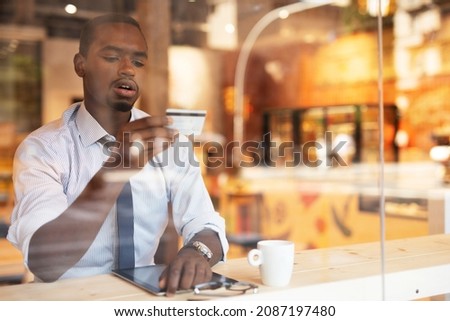 Businessman in cafe holding a credit card. Guy making online payment. Man paying the bill in cafe with a credit card.