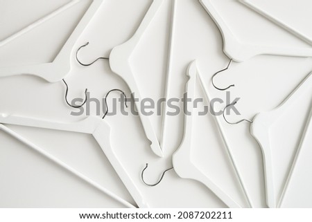 White wooden clothes hangers and coat hangers on a white background.
Sale and shopping concept.