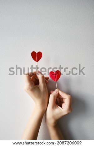 Two red hearts in hands on a light background. Love concept, Valentine's Day.