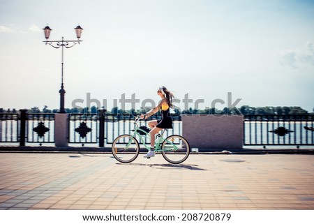 stylish girl hipster riding a  cruiser bicycle Royalty-Free Stock Photo #208720879