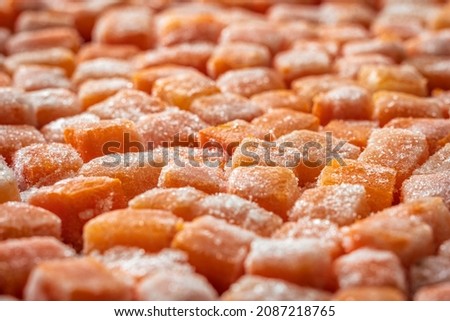Frozen fresh carrot cube pieces closeup background
