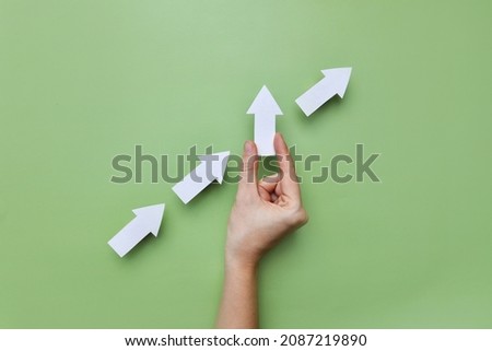 Many white arrows point to the left, and one arrow points up. A symbol of an innovative, different way of life and business Royalty-Free Stock Photo #2087219890