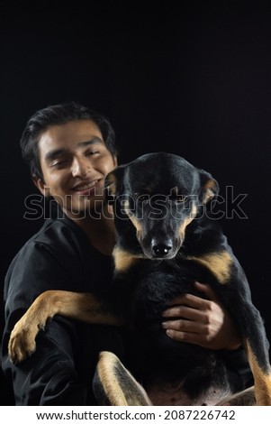 boy carrying his dog, both posing for the picture, the dog has a tender and happy face, he feels the love of his human and has a good time.