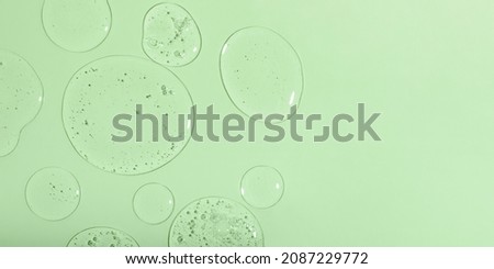 Top view of liquid cosmetics gel with bubbly structure on green background.Good as cosmetic mockup,large banner.