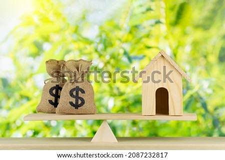 Home and money bag Us dollar sign put on the scales with balance saving for a real estate concept loan for plan business investment in the future