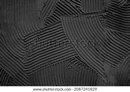 Embossed decorative plaster pattern with a pronounced black structure. Background. Texture.