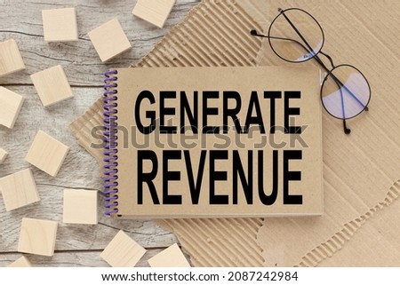 GENERATE REVENUE. notepad on a wooden table. Business concept.