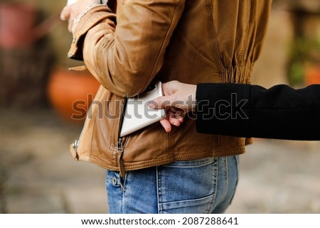 Pickpocket thief is stealing smartphone outdoors Royalty-Free Stock Photo #2087288641