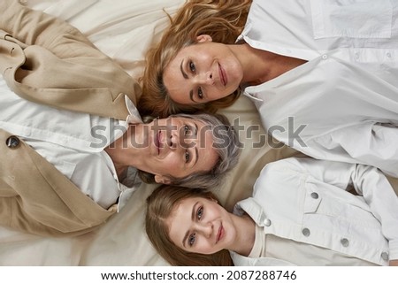 Top view portrait of three generations of Caucasian women, girl child, mother and grandmother, on one picture. Smiling kid daughter with mom and old grandma unity. Descendant, offspring.
