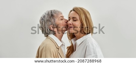 Wide web banner shot of loving senior mother kiss happy adult daughter in cheek feel thankful grateful. Caring mature mom caress grownup woman child. Offspring, motherhood concept.