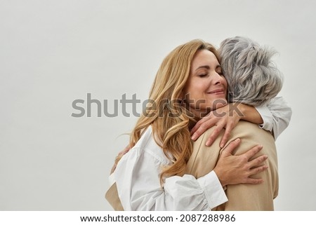 Happy loving young grownup daughter embrace mature mom show care and gratitude. Smiling adult woman child hug senior mother feel thankful grateful. Motherhood, family unity concept. Royalty-Free Stock Photo #2087288986