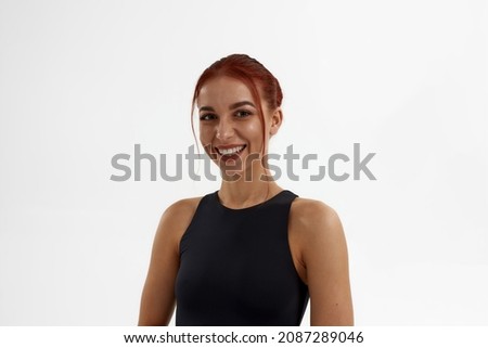 Smiling caucasian female ballet dancer looking at camera. Young slim attractive woman with red hair and wearing leotard. Girl isolated on white background. Studio shoot. Copy space