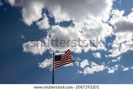 American flag waving on a background of cloudy blue sky