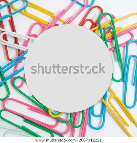 Creative layout made colorful paper clips on a white background. Round paper card.  School, and eduaction idea.
