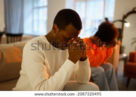 Depressed offended african man thinks about divorce or break up after quarrel with beloved woman at home, upset afro american couple wife and husband sit on sofa after fight. Problems in marriage Royalty-Free Stock Photo #2087320495