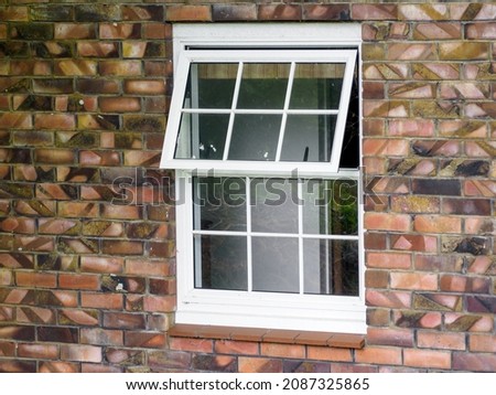 White wooden divided awning window on brick wall