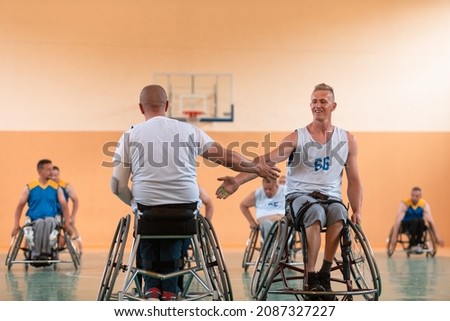 a team of person with a disability in wheelchairs playing basketball, celebrating points won in a game. High five concept