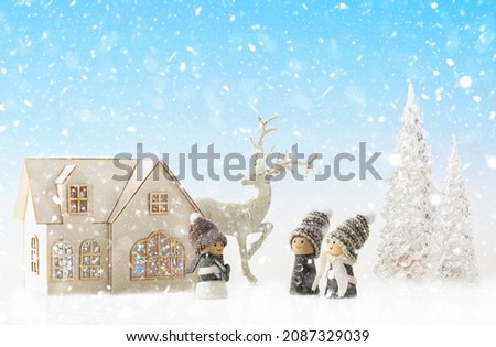 Christmas decor. Christmas fairy tale on a snowy background, family concept. House with Christmas lights, reindeer, ice trees and cute gnomes.