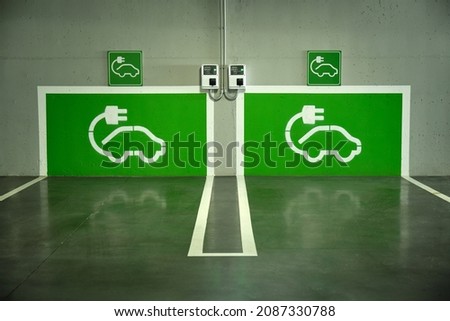 image of a parking lot with two electric car charging points painted green on the wall