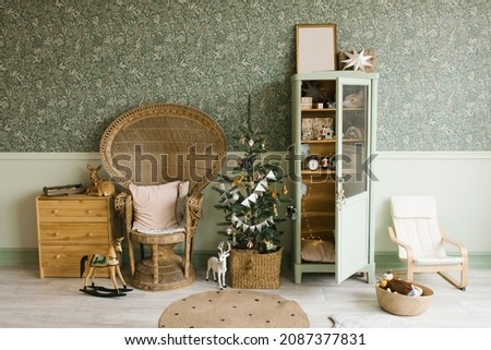 Scandinavian mint Christmas interior with decorated Christmas tree in children's room. Wardrobe with children's toys, wicker chair, chest of drawers