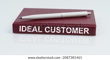 Business and finance concept. On a white surface lies a pen and a notebook with the inscription - IDEAL CUSTOMER