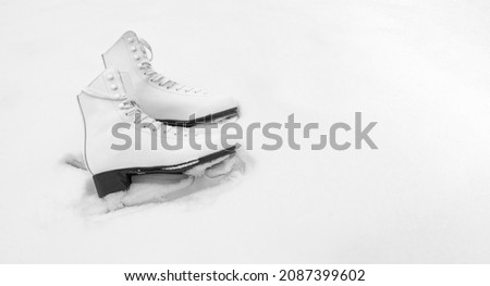 White figure skates on natural snow background top view. Copy space