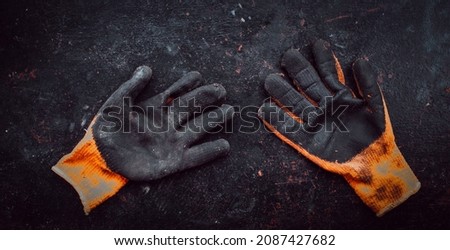 Old work gloves on a black background