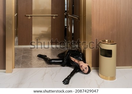 Hit woman. Woman in a latex suit killed in gunfire shot in the chest

 Royalty-Free Stock Photo #2087429047