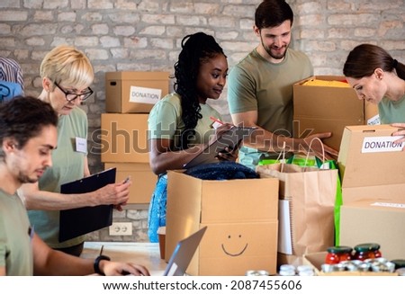 Group of volunteers with working in community charity donation center. Royalty-Free Stock Photo #2087455606