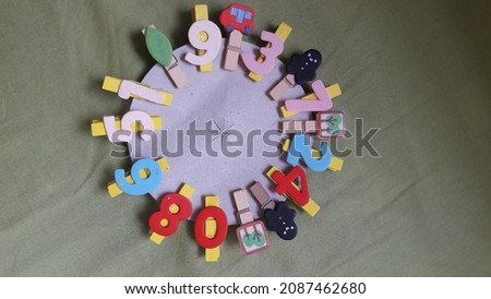 Number pegs and pegs with pictures on a soft green cloth, very suitable for introducing numbers to children.